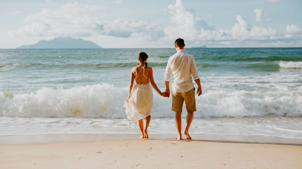 Couple walking hand-in-hand on Punta Mita beach at sunset